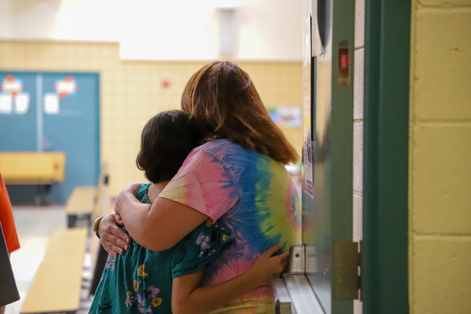 A Banks Elementary student gets a hug on the first day of school